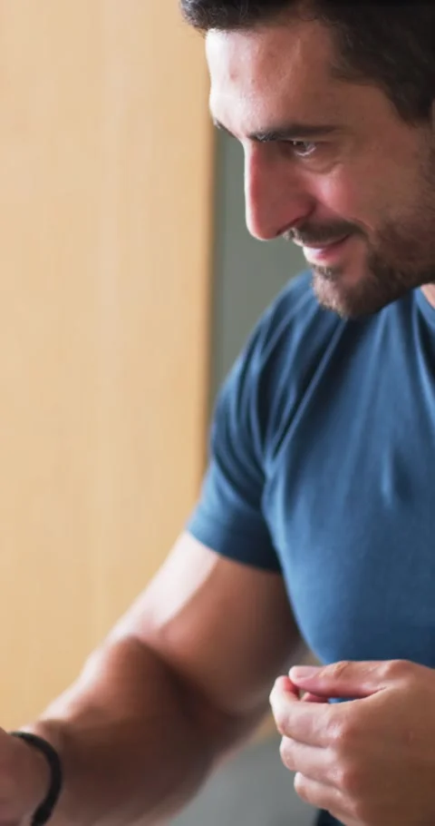 Man feeling eye itch, inspecting face with round mirror at sink wearing navy Stock Footage 345219227