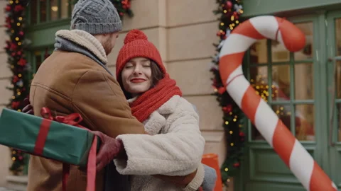 The man feeling happy is giving his girlfriend christmas gift and then hugging Video stock 221316632