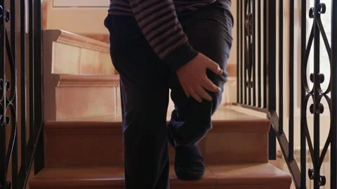 Man feeling leg pain while walking down the stairs 스톡 동영상 332048902