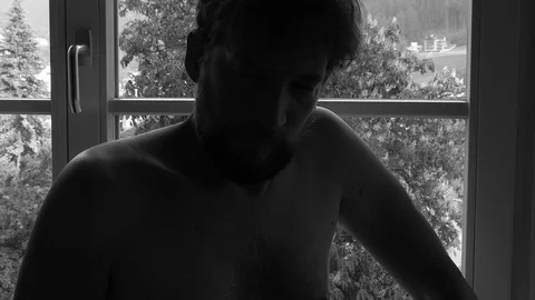 Man feeling lonely after breakup in front of window black and white closeup Stock Footage 76624165
