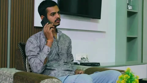 Man feeling relieved and smiling while receiving happy news on a smartphone call 動画素材 330390885