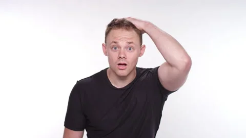 Man feeling shocked and surprised while rubbing his head and grabbing his chest Stock-Footage 131783785