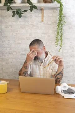 Man feeling stressed while working remotely at home Stock Photos