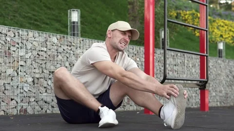 A man feels a sharp pain in his foot and massages the painful leg. Vídeo Stock 252824454