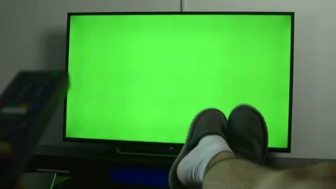 Man With Feet On The Coffe Table Changing Channels On A Green Screen TV Vídeos de archivo 84167440