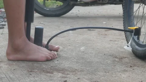 A man feet holding the base of a manual hand pump Stock Footage 332866892