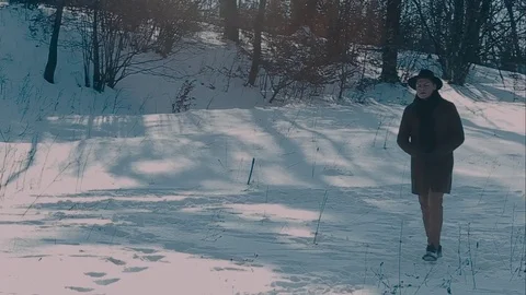 A man in a felt hat and coat comes in the winter woods. brown hat made of felt 動画素材 72411085