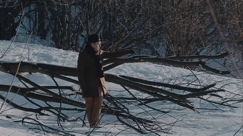 A man in a felt hat and coat comes in the winter woods. brown hat made of felt 動画素材 72411562