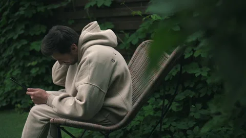 Man felt neck pain while sitting in the garden with tablet Stock Footage 160947066