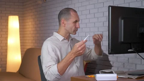 Man with fever having video call consultation with doctor 库存影片 333393329