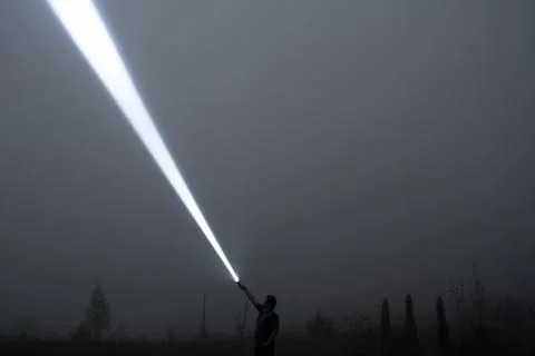 Man in the field at night with a flashlight 스톡 사진