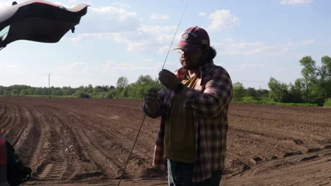 A man in a field opens the boot of a car Vídeos de archivo 276723797