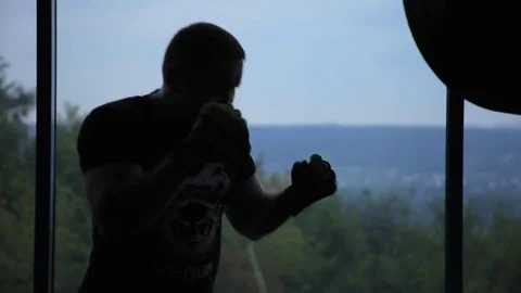 A man is fighting with a shadow in the gym opposite the window Stock-Footage 76150812