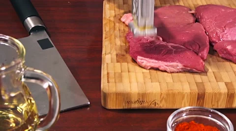 Man fights off raw meat beef steak before frying it slow motion Stock Footage 66448680