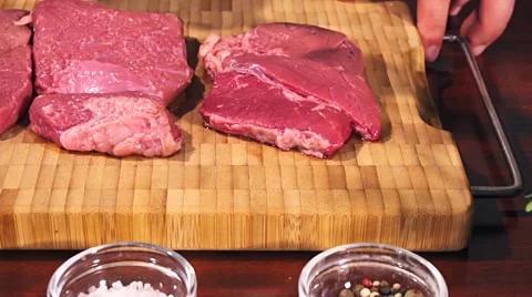 Man fights off raw meat beef steak before frying it slow motion Stock Footage 66448939