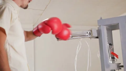 Man fights, trains with mechanical robot boxer. Gloved hand. teaching Vídeo Stock 204970628