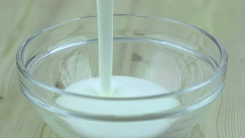 Man fill the transparent cup with white yogurt, ready for insert healthy Stock Footage 89369997