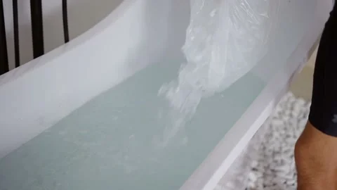 Man filling bath with ice cubes Stock Footage 159645080