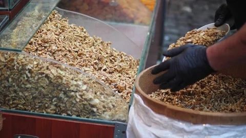 Man fills container with nuts in busy market Stock Footage 341908241
