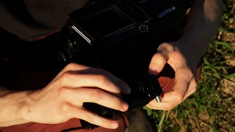 Man fills the film in the camera in the sun Stock Footage