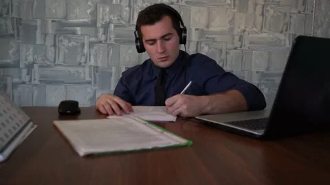 Man fills out paper while sitting at his workplace Video stock 145220646