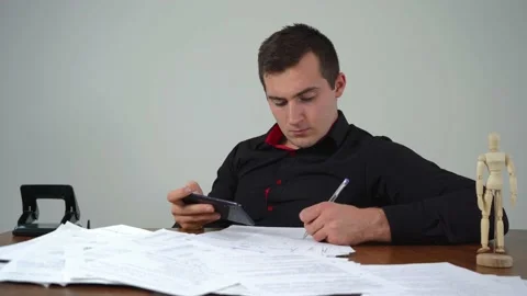 A man fills out paperwork while sitting at his office at the table 스톡 동영상 158830515