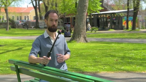 Man Filming Himself with a Smartphone on a Selfie Stick Stock Footage 308637751