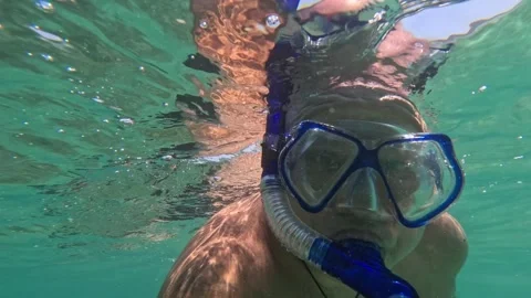 Man filming himself underwater while snorkeling 스톡 동영상 339073025
