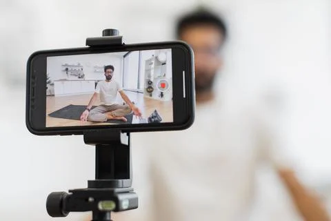 Man filming meditation tutorial for online health and wellness video blog. 写真素材