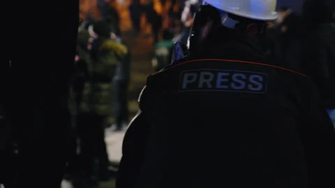 A man films and broadcasts a protest, with a crowd of police in the frame Stock-Footage 298006841