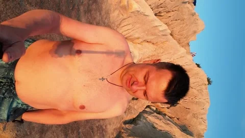 A man films himself wading into the clear waters of a lake on an early summ.. Stock-Footage 249671531