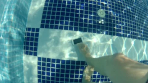 Man find drown smartphone at pool bottom, picks it up and give to girl child Stock Footage 82077385