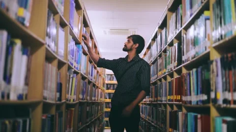 Man finding book in library Stock Footage 249286704