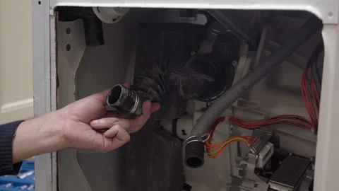 Man finding coins inside a clogged washing machine drain pipe. Stock Footage 343728932