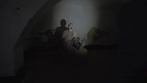 Man finding ghost with cage on his head in gloomy basement of abandoned asylum. Stock Footage 245577240