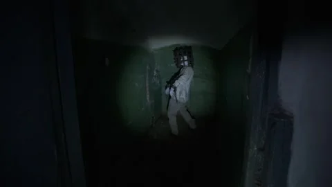 Man finding ghost with cage on his head in basement of abandoned asylum POV shot Stock Footage 245578570
