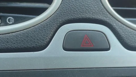 Man finger pressing hazard warning light button on car dashboard Stock Footage 344981047