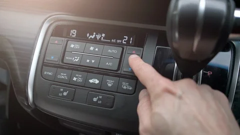 Man finger pushing buttons on сar сlimate сontrol system on car dashboard Stock Footage 130076490
