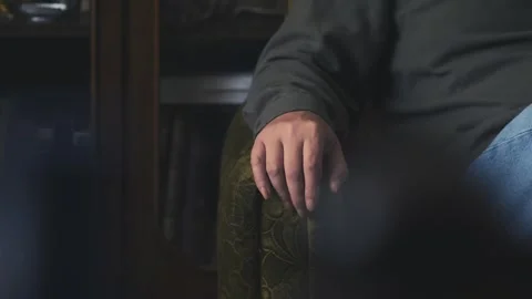 Man finger tapping while sitting in comfy Armchair MEDIUM SHOT Stock Footage 311572709