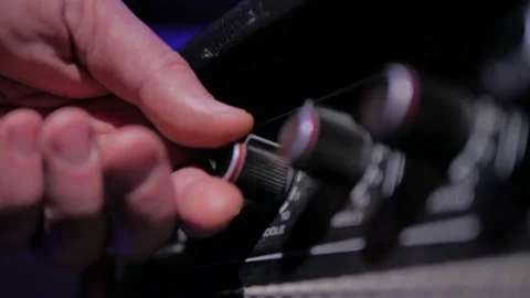 Man finger twists knobs on guitar amps in studio Video stock 195514312
