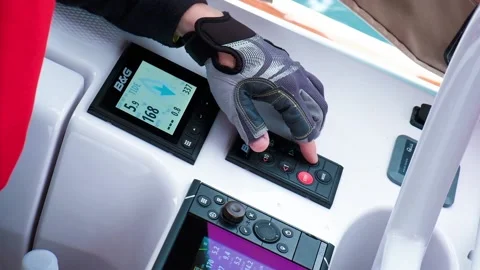 Man in fingerless gloves presses key on yacht dashboard Video stock 168364969