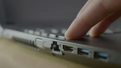 Man fingers plugging in the ethernet cable into the port of his laptop to che Stock Footage 87014386