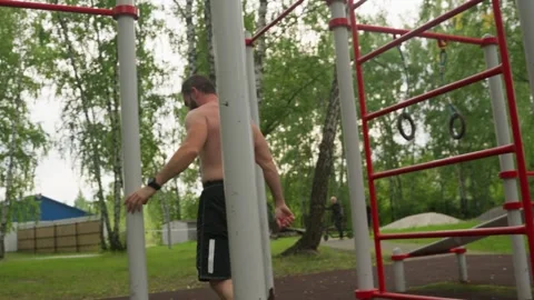 Man Finishes Exercise on Outdoor Calisthenics Bars 스톡 동영상 330921353