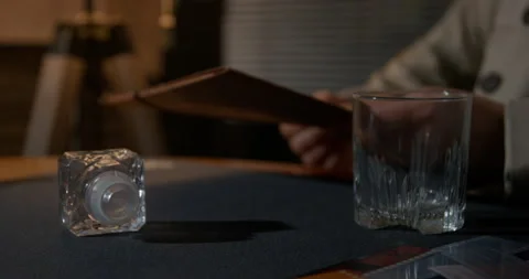 Man finishes whiskey putting empty glass on table in office Stock Footage 249710971