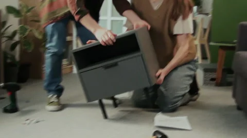 Man Finishing Flatpack Drawer Assembly, Hugging and Kissing Wife Stock Footage 330522215