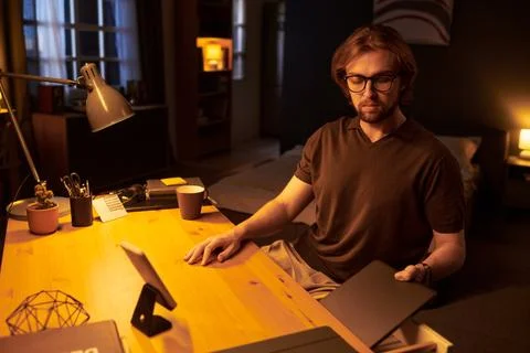 Man Finishing Remote Work and Storing Laptop in Desk Drawer at Home Stock Photos