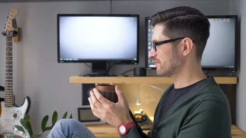 A man finishing work at a remote workplace. A freelance person who has a coffee Video stock 129993314