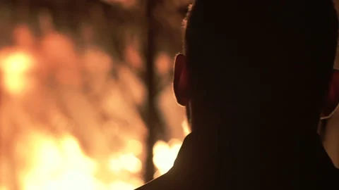 Man on fire background, a man against a burning house at night Stock Footage 98865721