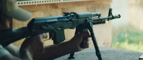Man fires rifle with bipod support as shell casing ejects during shooting Stock Footage 310233677