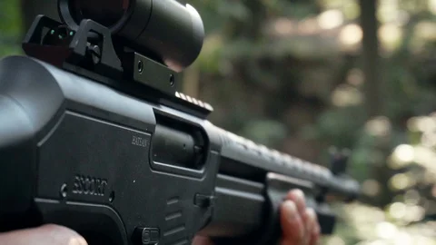 A man fires a shotgun and ejects a smoking shell from the chamber in slow motion Stock Footage 98463442